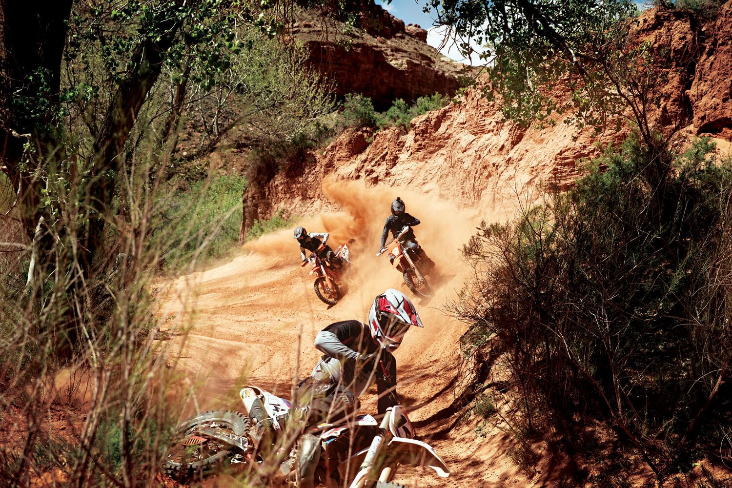 A group of enduro riders on a series of turns. 